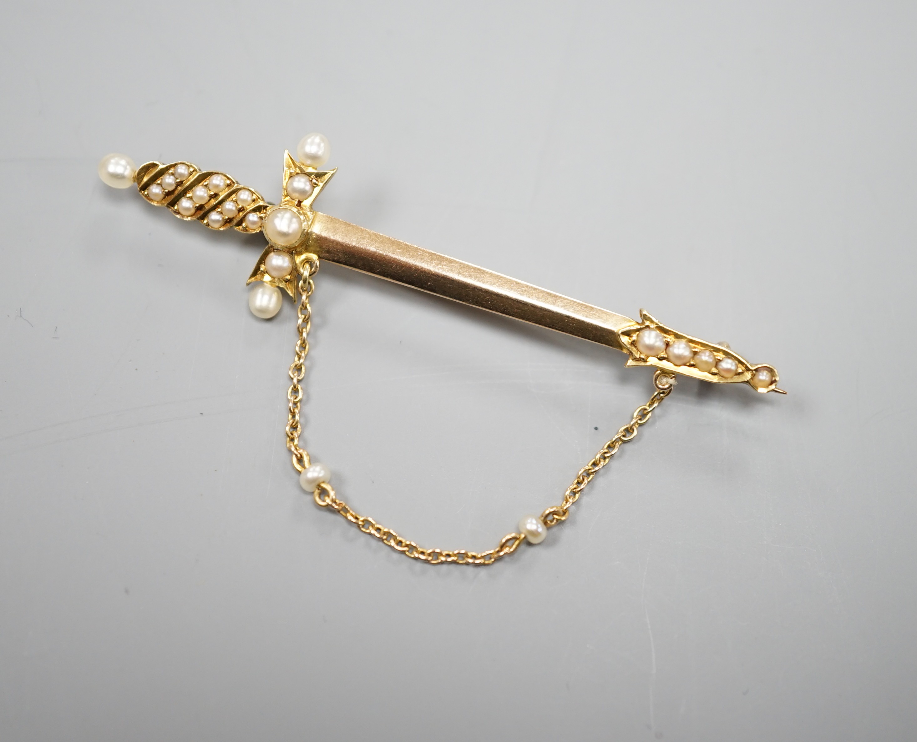 An Edwardian yellow metal and graduated seed pearl set dagger bar brooch, 60mm, gross weight 5 grams.